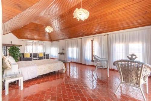 Quarto deluxe espaçoso na Villa Principezinho com teto de madeira, ladrilhos em terracota e vista para o mar