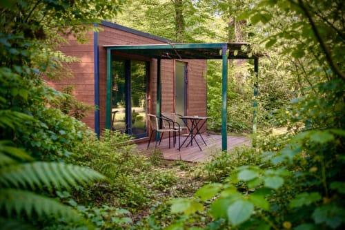 Modernes Ferienhaus mit Terrasse in Les Lodges de Vaugrigneuse, umgeben von üppig grünem Wald in Frankreich