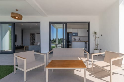 Patio moderno en G&H Apartments con zona de descanso, mesa de madera y vistas al lago en Jerez de la Frontera
