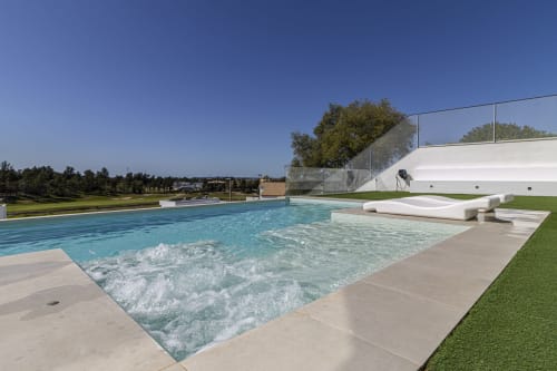 Lujosa piscina infinity en G&H Apartments de Jerez de la Frontera con tumbonas de terraza y jardines impecables