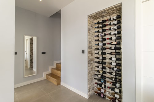 Bodega moderna con botellas montadas en pared en la casa de lujo G&H Apartments en Jerez de la Frontera