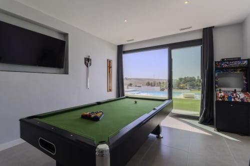 Sala de juegos moderna en la casita de G&H Apartments en Jerez de la Frontera con mesa de billar, TV de pantalla plana y vistas al lago