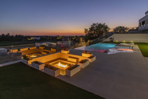 Piscina infinita de lujo y lounge con chimenea en G&H Apartments de Jerez de la Frontera al atardecer