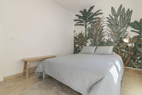 Dormitorio moderno en G&H Apartments Jerez con mural botánico, cama queen, banco de madera y luz natural