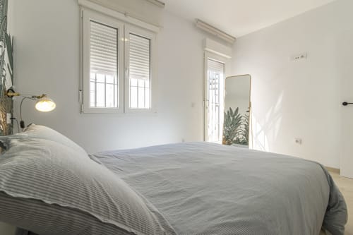 Dormitorio moderno y luminoso en G&H Apartments Jerez con cama matrimonial, vistas al jardín y mobiliario contemporáneo