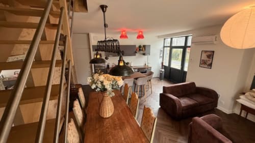 Open-plan living area at Les Petits Nids apartment in Vouillé with dining table, kitchen, and lounge seating