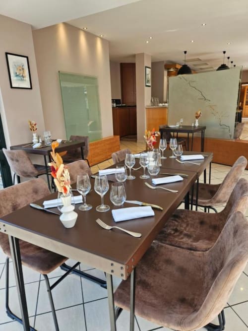 Salle à manger élégante du restaurant La Route d'Argent à Bozouls avec tables dressées, verres à vin et décoration moderne