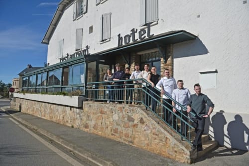 Le personnel de l'hôtel La Route d'Argent posant sur les marches d'entrée à Bozouls, France