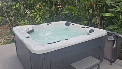 Luxuriöser Whirlpool mit türkisfarbenem Wasser umgeben von tropischen Pflanzen auf der Habitation Villa Les Cassias, Guadeloupe