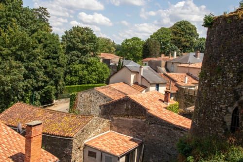 Vue aérienne de l'Appart'Hôtel de Cholet avec toits en terre cuite, bâtiments en pierre et arbres environnants