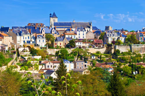 Petite ville médiévale de Cholet avec son clocher d'église et ses façades colorées nichées sur la colline