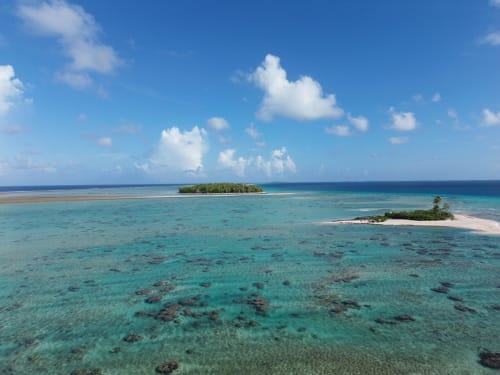 Lagon turquoise avec deux îles tropicales et plage de sable blanc à Tikehau, Polynésie française