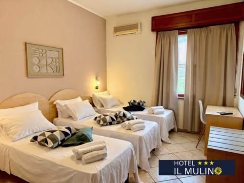 Hotel Il Mulino triple bedroom with twin beds, sea view windows, and coastal ambiance in Villalunga