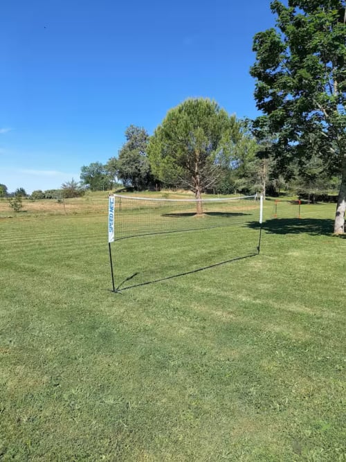Filet de volley-ball installé sur la pelouse du jardin des Gîtes Le Pech à Sainte-Foy-de-Longas