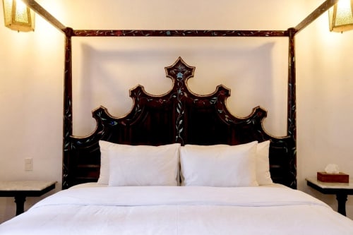 Ornate black canopy bed with white linens in Chambre 2 at Villa Merida Boutique Hotel, Merida