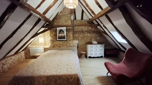 Chambre spacieuse aménagée en grenier à Le Cottage, Gîtes Le Pech, avec poutres apparentes, murs en pierre, mobilier moderne et vue sur rivière