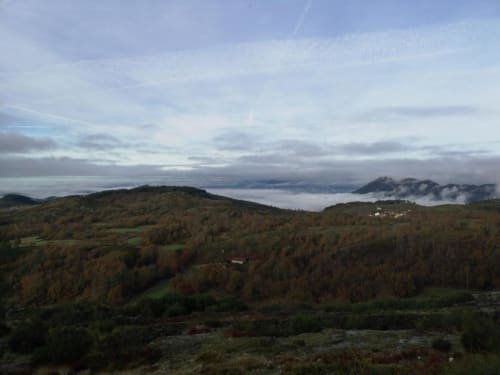 Montanhas enevoadas e colinas florestadas ao redor da Casa da Avó Ana em Mondim de Basto, Portugal, com vistas do vale abaixo