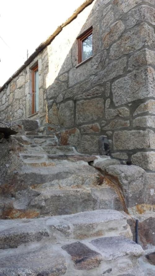 Entrada de casa de pedra com terraço, janelas de madeira e degraus rústicos em Casa da Avó Ana, Bobal, Portugal