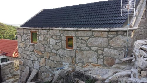 Casa da Avó Ana em Bobal: chalé de pedra com telhado escuro, duas janelas e vistas do jardim na serra portuguesa