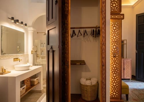 Baño de lujo en Villa Merida Boutique Hotel en Mérida con espejo iluminado, lavabo tipo vasija y biombos decorativos de madera
