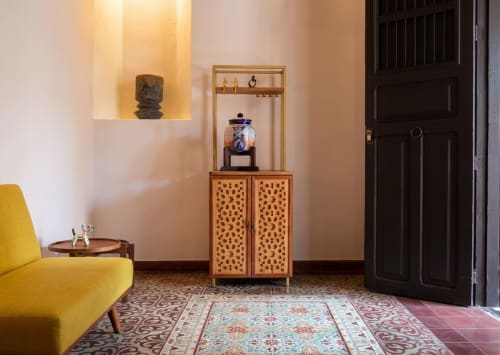 Habitación del Hotel Boutique Villa Merida con silla amarilla, vitrina de madera y decoración mexicana tradicional en Mérida