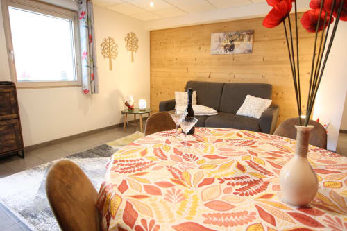 Appartement cosy 'La Gentiane' au Domaine des Fleurs à Gérardmer avec literie florale, murs en bois et vue montagne