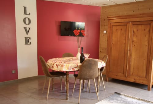Coin repas romantique dans l'appartement La Gentiane au Domaine des Fleurs à Gérardmer avec décoration murale LOVE