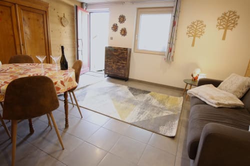 Séjour cosy au Domaine des Fleurs à Gérardmer avec table à manger, canapé et vue sur les montagnes