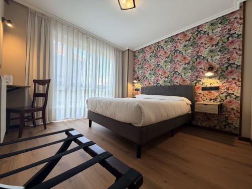 Moderna habitación doble en Hotel Puerto De Candás, Asturias, con pared de acento floral, vistas a la ciudad y suelos de madera