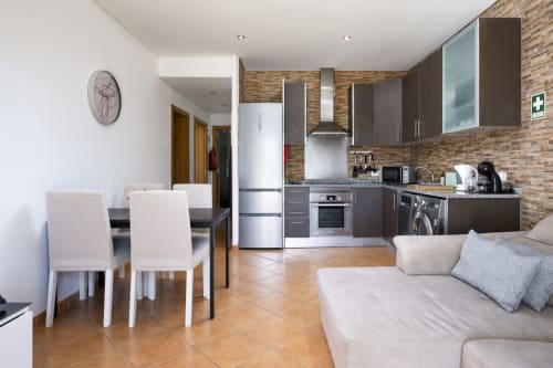 Apartamento PEDRO em RB Algarve Vilamoura com cozinha aberta, sala de jantar e estar integrados, paredes de tijolo e design moderno