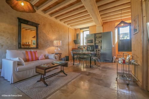 Salon chaleureux aux poutres bois de la Casa Pertica B&B à Ceton, France, avec canapé confortable et espace de travail