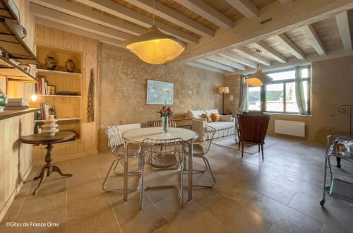 Espace repas de Casa Pertica à Ceton avec table ronde, poutres en bois et mobilier contemporain