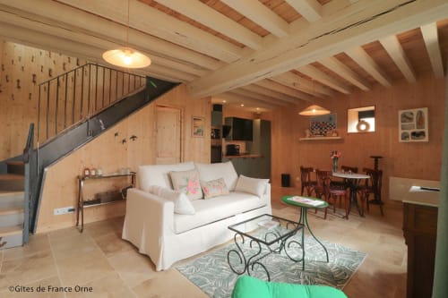 Salon rustique en bois de la Casa Pertica B&B à Ceton avec canapé crème, plafond à poutres et coin repas