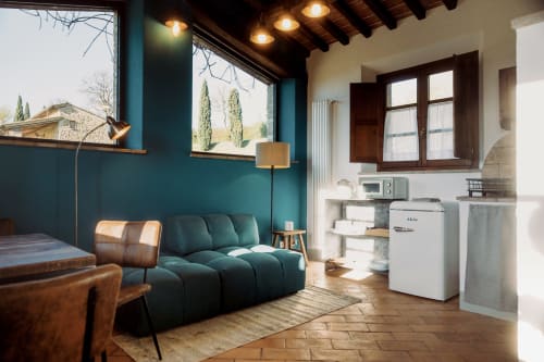 Studio moderno presso l'Agriturismo Il Serraglio a Montepulciano con pareti turchesi, divano scultoreo, angolo cottura e stile toscano