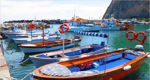 Coloratissime barche da pesca ormeggiate nelle acque turchesi del porto vicino al Villa Bina Sea Hotel, Serrara Fontana