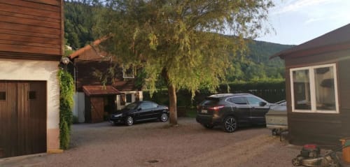 Allée du Chalet Cossu avec voitures garées, montagnes et vue sur le jardin aux Gîtes les Grandes voies