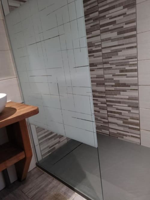 Salle de bains moderne avec douche vitrée et mur d'accent en carrelage rayé au Chalet Cossu, Le Ménil