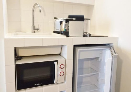 Petite kitchenette équipée au studio Versailles BnB avec micro-ondes, réfrigérateur, évier, cafetière et robinet