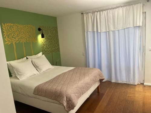 Chambre moderne à la décoration épurée au Denis & Virginie B&B à Versailles avec mur vert, literie blanche et accès patio