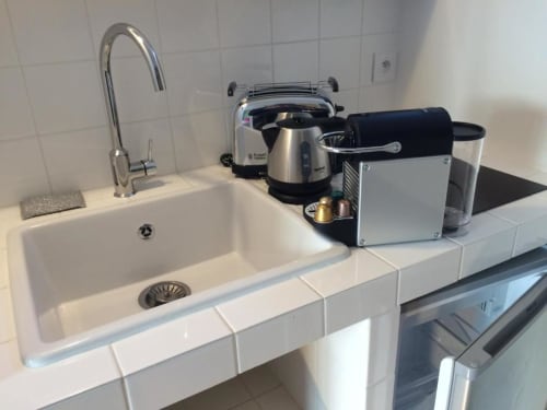 Kitchenette équipée au Denis & Virginie BnB Versailles : évier, robinet, cafetière et grille-pain sur plan de travail blanc