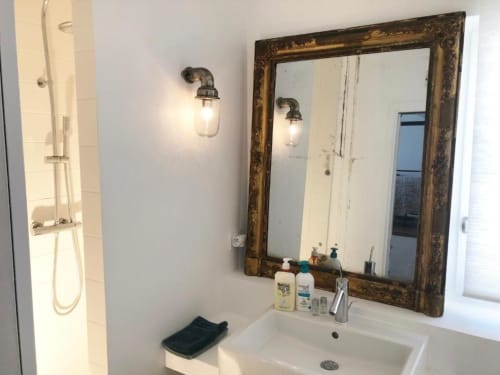 Lavabo moderne avec miroir encadré doré et appliques murales à la chambre d'hôtes Denis & Virginie à Versailles