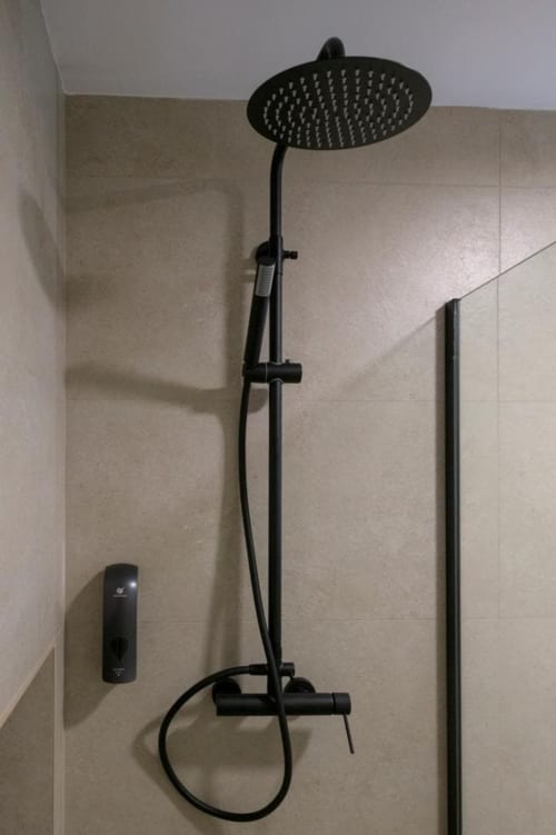 Mampara de ducha negra y grifo termostático en el baño de ML Apartments, Valencia
