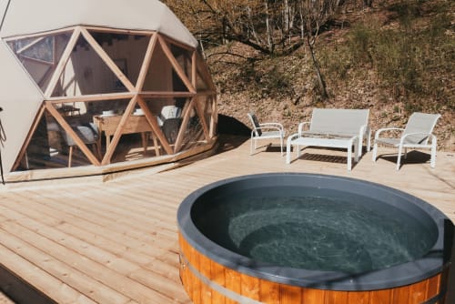Geodesic dome cottage at Les Cabanes du Nideck with hot tub on wooden deck, Oberhaslach