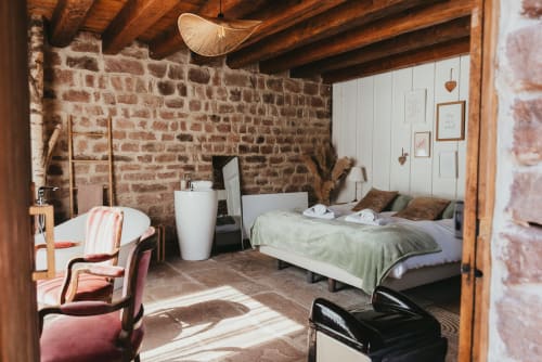 Rustic bedroom at Les Cabanes du Nideck cottage in Oberhaslach with exposed brick walls and wooden beams
