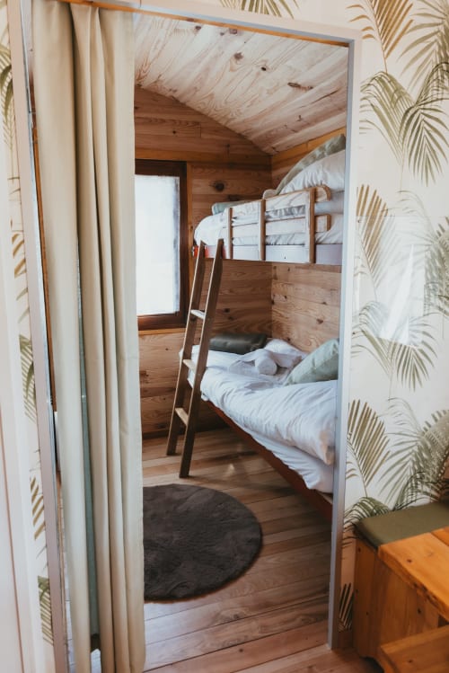 Cozy wooden cottage bedroom with bunk beds at Les Cabanes du Nideck, Oberhaslach