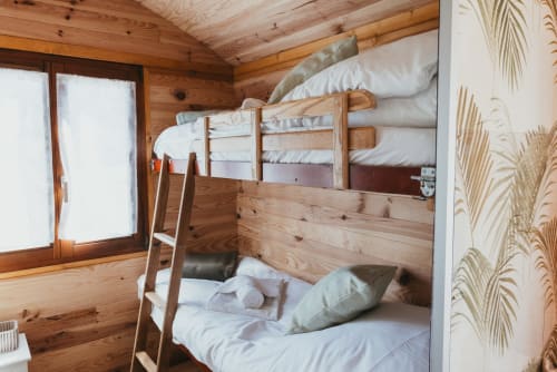 Cozy wooden bunk bed cottage bedroom at Les Cabanes du Nideck in Oberhaslach with white bedding and mountain views