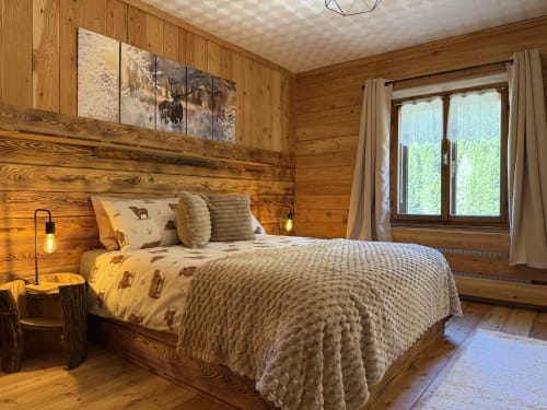 Cozy wood chalet bedroom with mountain views, rustic furnishings, and nature-themed decor in Auronzo di Cadore