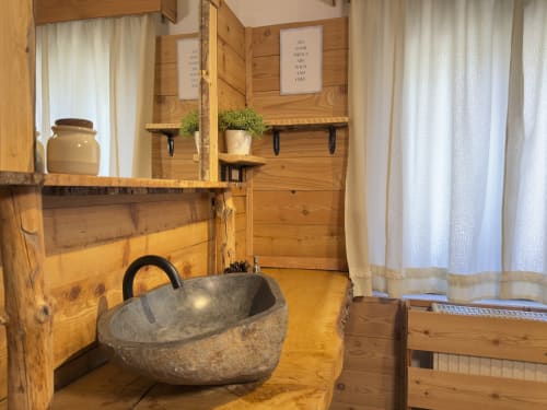 Rustic wooden chalet bathroom in Auronzo di Cadore with stone sink and mountain views