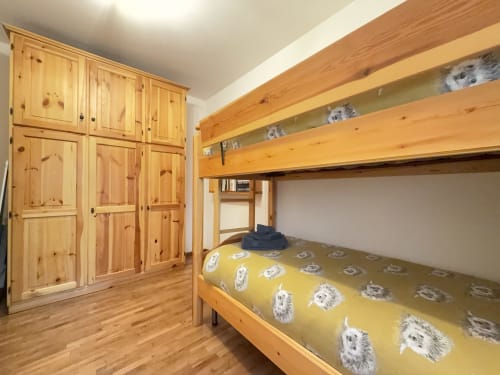 Camera da letto accogliente con letto a castello in legno e mobili in pino nell'appartamento di montagna ad Auronzo di Cadore