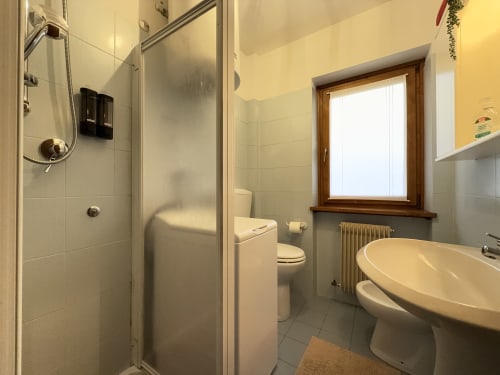 Moderno bagno nell'appartamento CIMABOSCO di Auronzo di Cadore, con doccia walk-in, lavabo ovale, toilet e finestra